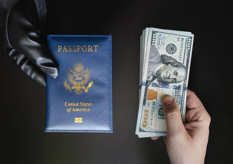 Hands holding passport USA and us dollar bills