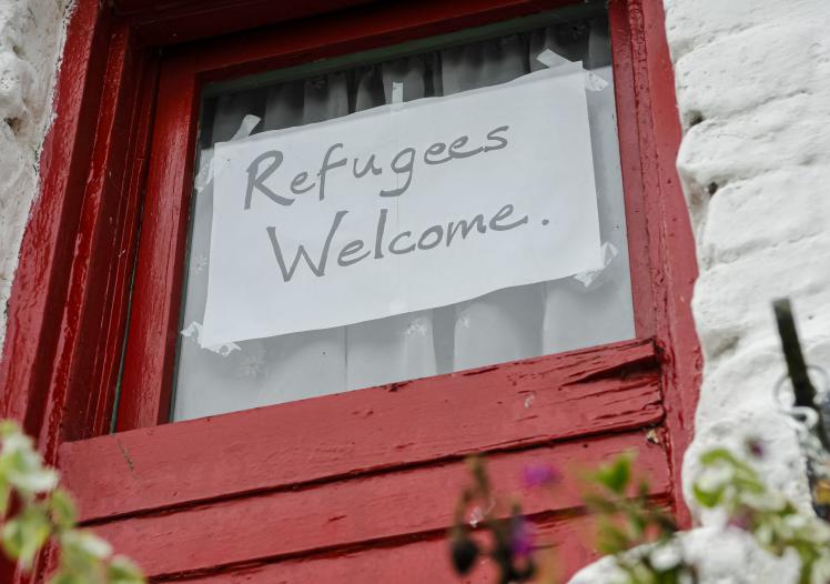 Sign on a window saying "Refugees Welcome"