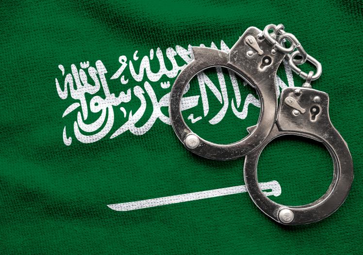 Flag of Saudi Arabia and police handcuffs
