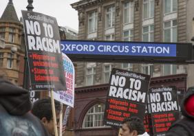 Antiracist march in central London. Protesters with placards and the entrance sign to Oxford Circus underground station.