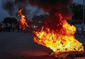 Burning tyres smolder on a road during a protest action