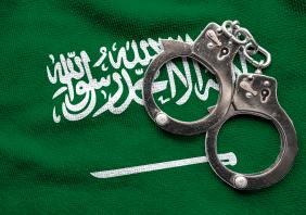 Flag of Saudi Arabia and police handcuffs