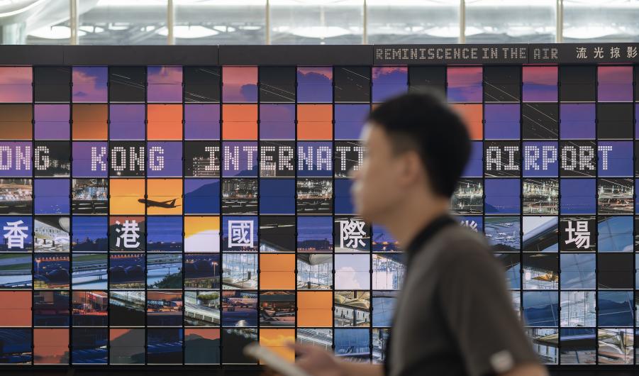 Man walking past the "Reminiscence in the Air" art installation at Hong Kong Airport