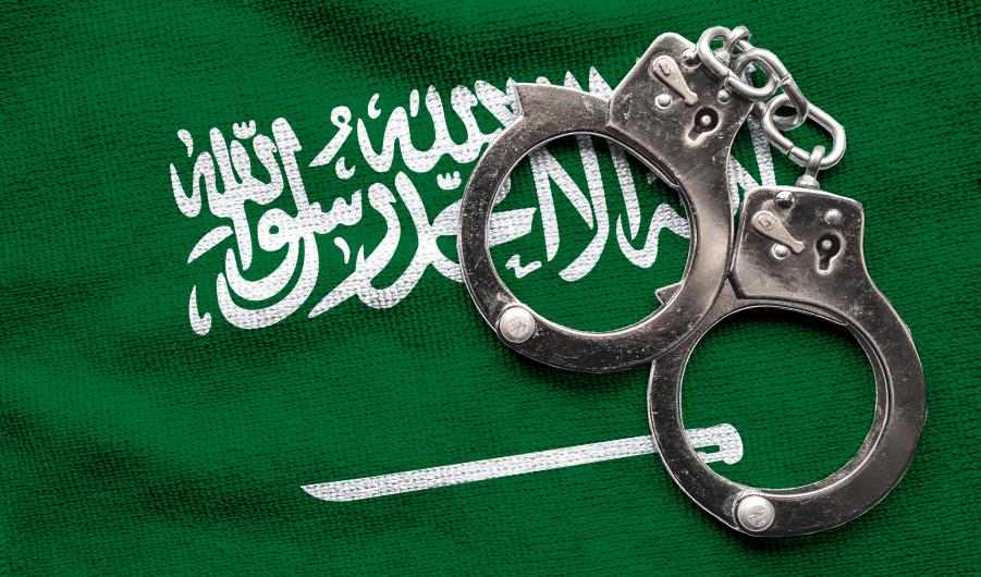 Flag of Saudi Arabia and police handcuffs